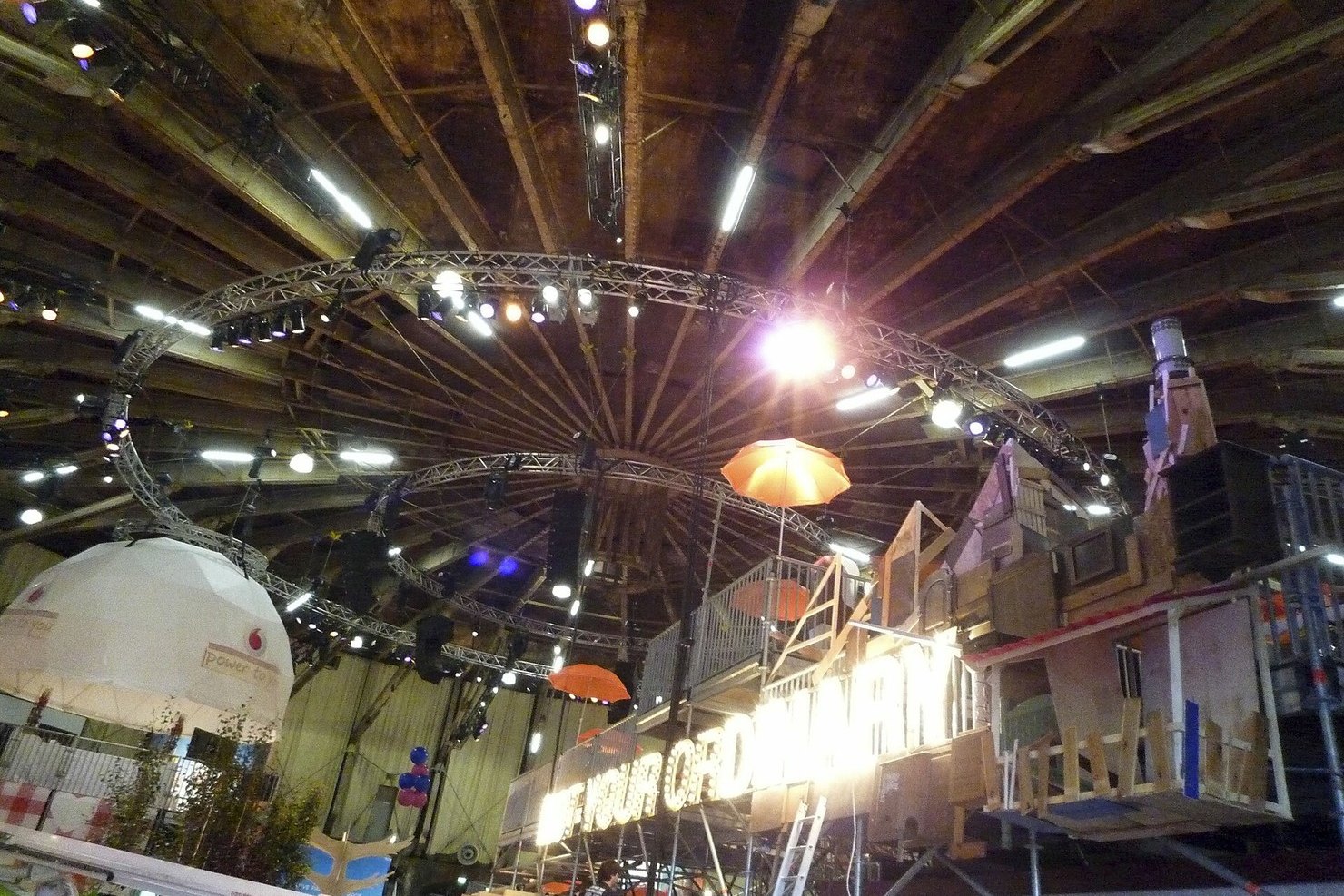 Inside the Gashouder at Westergas in Amsterdam: the round roof with radiating beams, circular lighting trusses and spotlights above an event set