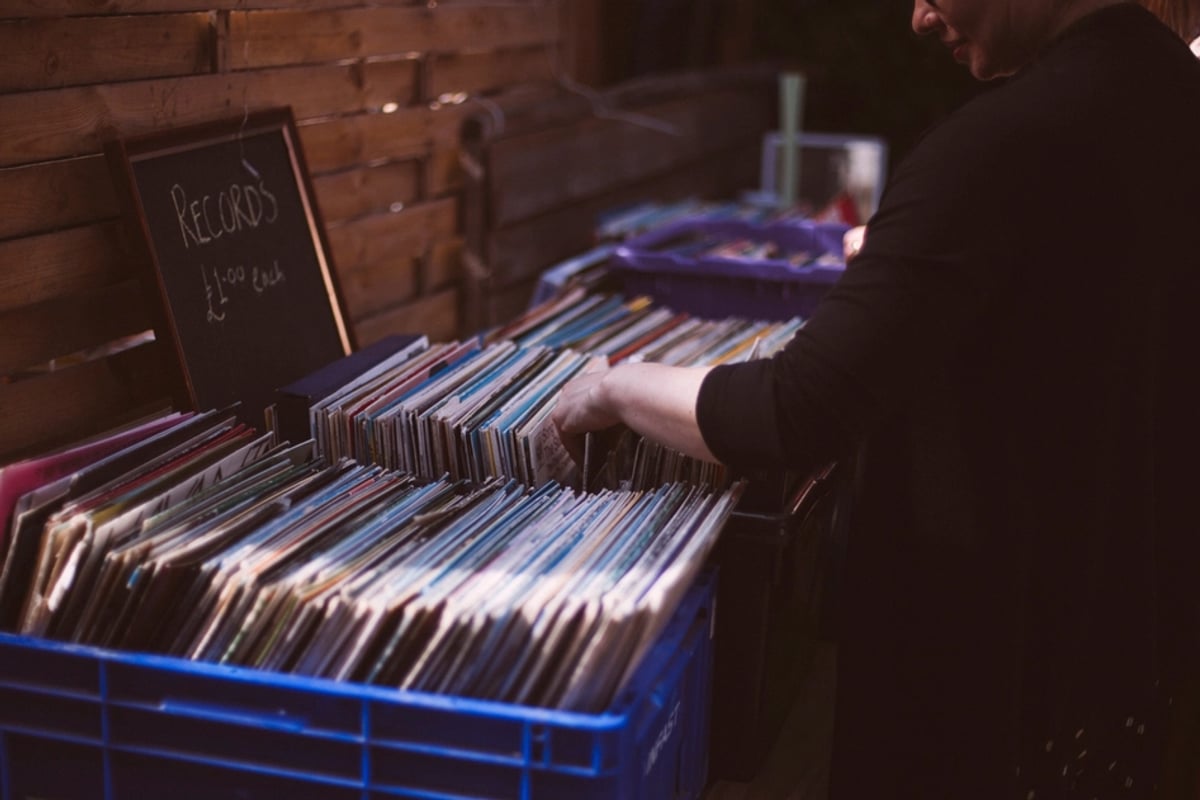 A digger flicking through a crate of twelve inch records in a record shop