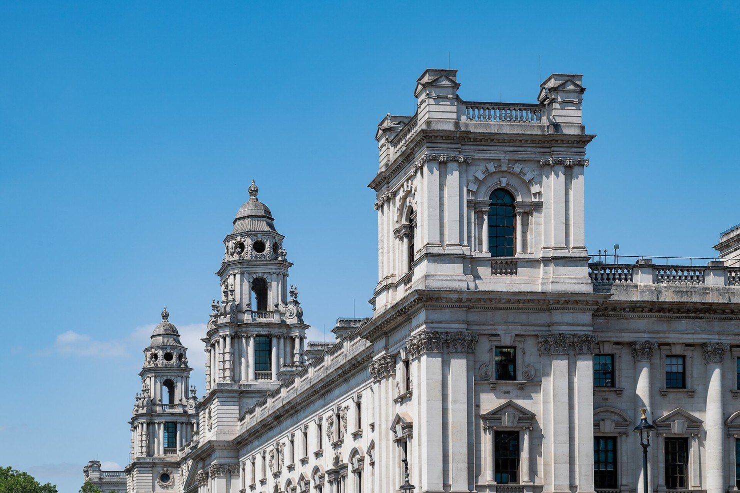 The white stone towers of the Government Offices Great George Street building, home of HM Treasury, against a clear blue sky in Westminster
