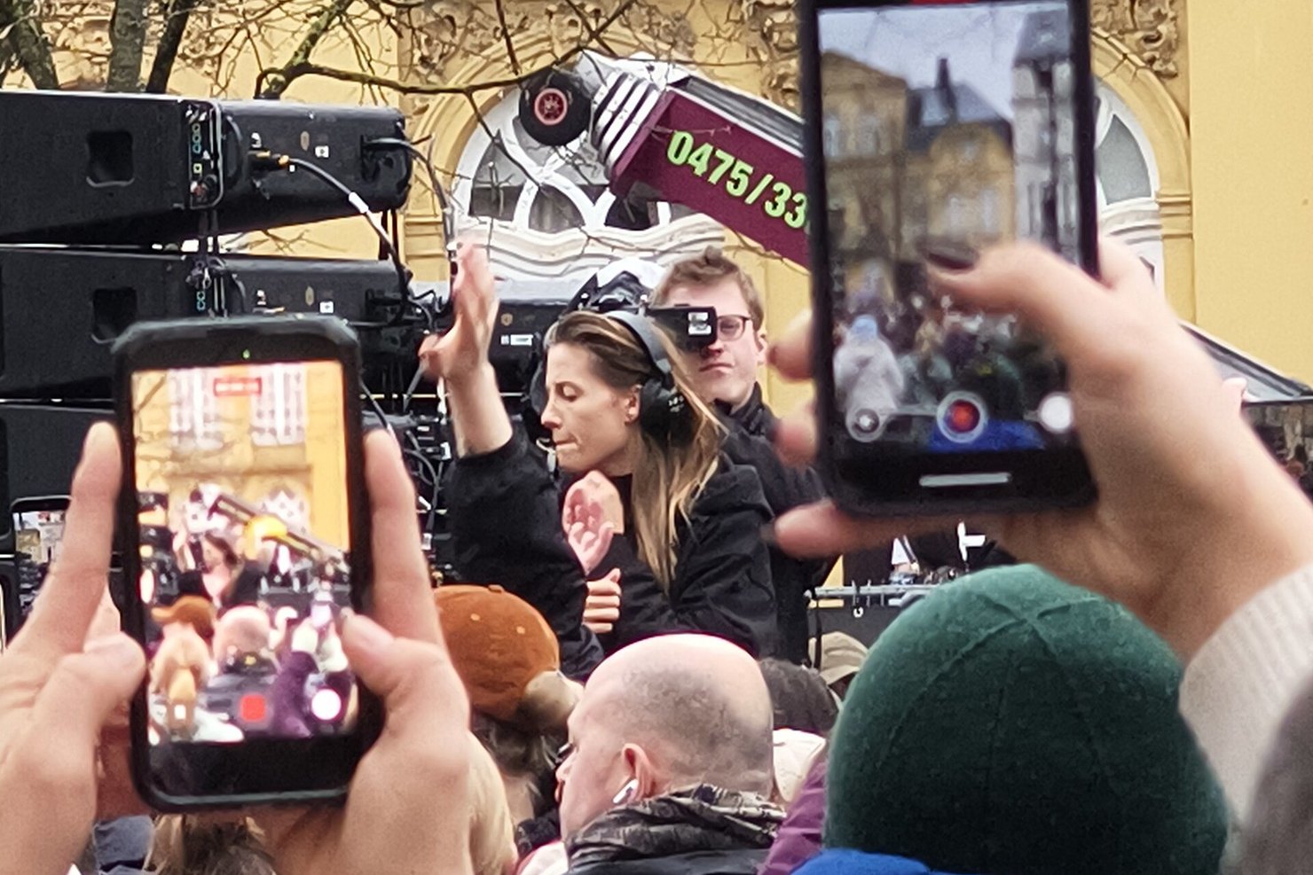 Charlotte de Witte DJing an outdoor set in Ghent on 6 February 2026, phones held up by the crowd in the foreground