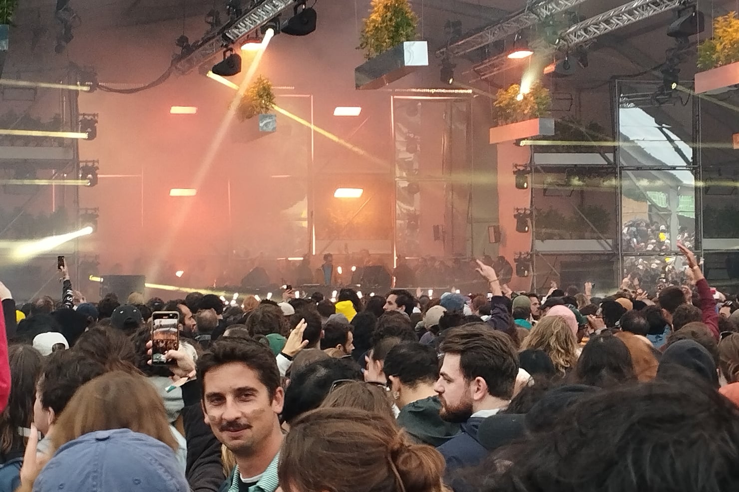 Four Tet performing in 2024, warm light over the crowd