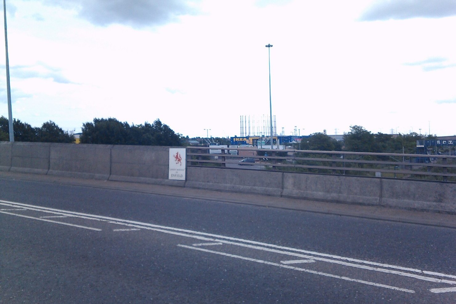 View from a road bridge on Conduit Way towards the blue and yellow IKEA store at Meridian Water in 2012, the building that is now Drumsheds, with a London Borough of Enfield sign on the parapet