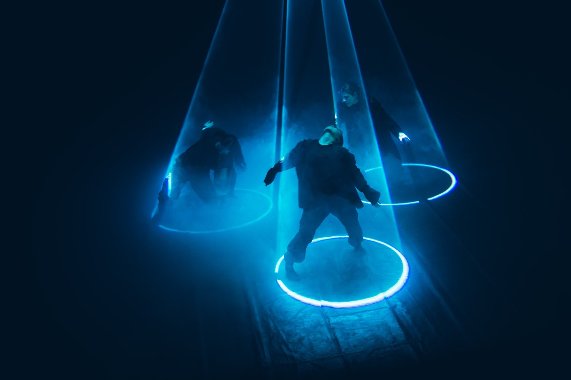 Dancers lit in blue rings of light in a Dance.Film.Performance production directed by Angelina Gorgaeva
