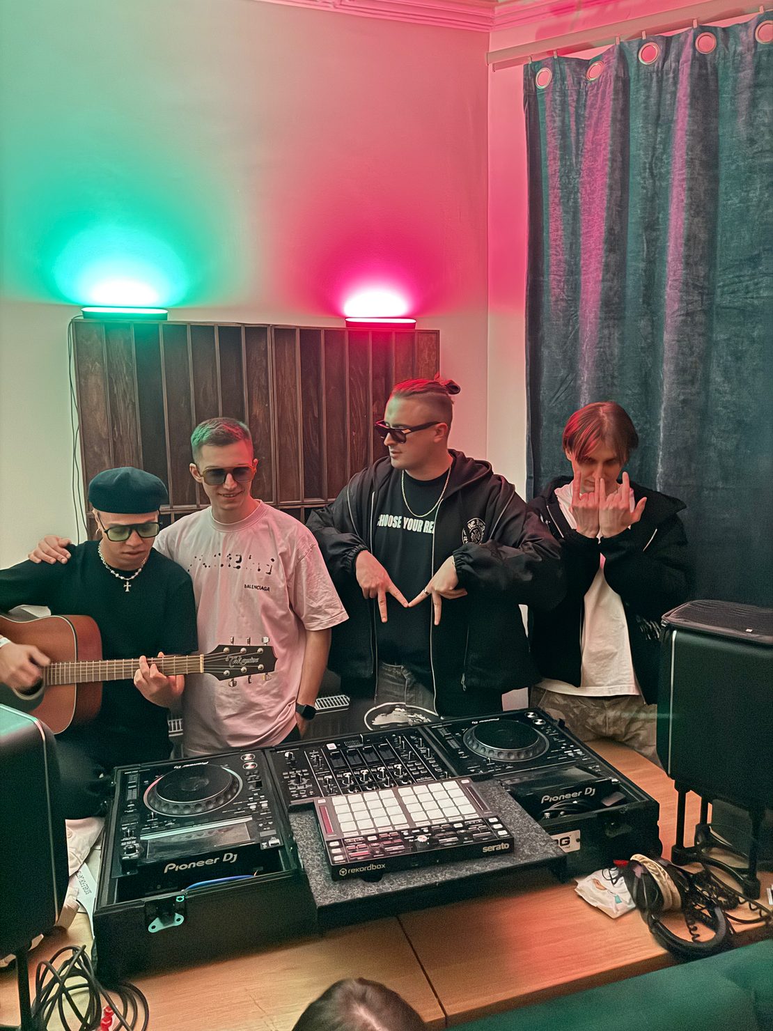 MNEEMO (Yaroslav Gorovoy), FLASH, SLAVKO and DANIEL OKARO standing in the music stiduo by the DJ desk. MNEEMO showning "M" Sign with his hands. 