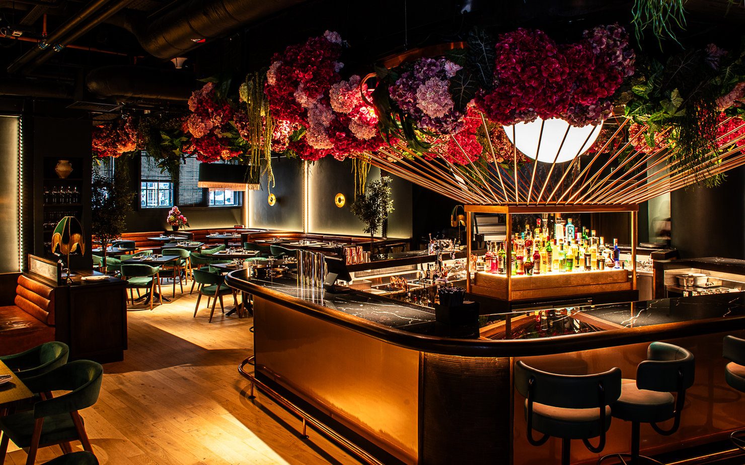 45 London on 45 Curtain Road.  Elegant bar interior with vibrant floral ceiling, dim lighting, and modern chairs. Bottles displayed on the counter, evoking a cozy ambiance.
