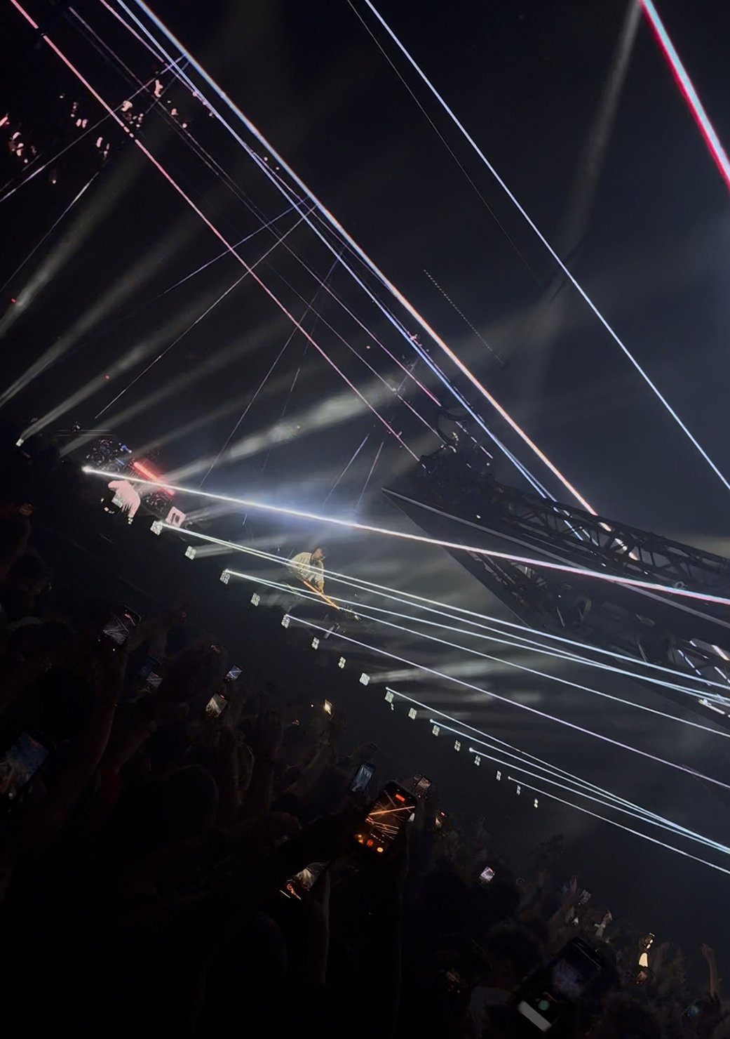 Sammy Virji DJing at Alexandra Palace on stage amid bright, colorful laser lights and a cheering crowd, creating an energetic concert atmosphere.  18 April 2026. 
