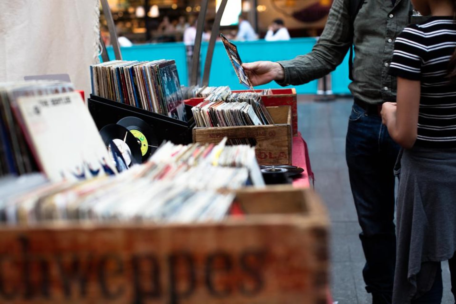 Crates of records at a vinyl market, a buyer flicking through